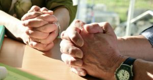 Two sets of hands in prayer