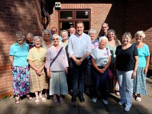 A group of people, including Tom Mprrison MP, standing outside a church.